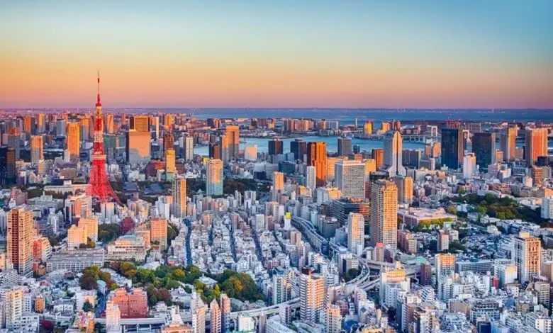 Pohled na Tokio s věží v západu slunce mezi mrakodrapy.