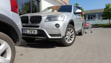 Stříbrný SUV parkovaný na asfaltovém místě ukazuje rozměry.