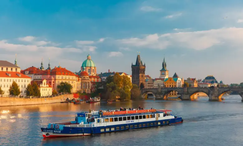 Pohled na řeku Vltavu v Praze s lodí mostem Karlovým.