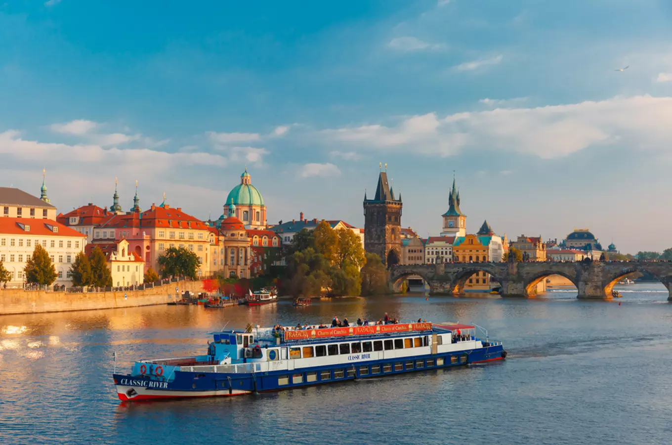 Pohled na řeku Vltavu v Praze s lodí mostem Karlovým.
