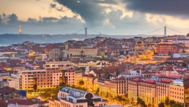 Panoramický pohled na Lisabon s mostem a věží v západu slunce