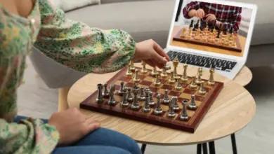 Žena hraje šachy s oponentem přes videotelefon doma.