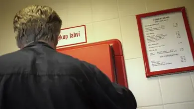 Muž vrací skleničku do automatu na výkup láhví.