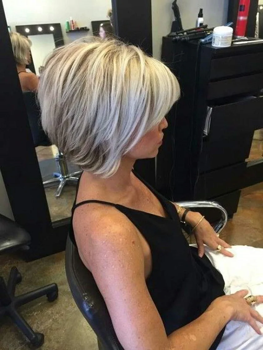 Žena s krátkými blond vlasy v kadeřnickém salónu