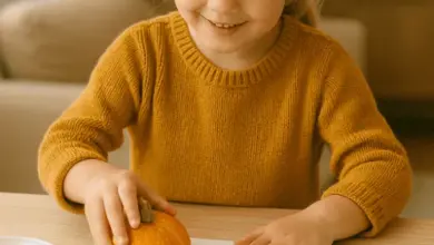 Dívka vytváří podzimní stopy z dýně na papíru.