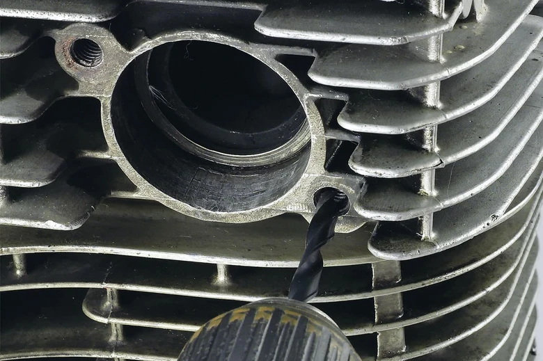 Vrtání do závitů hlavy válcového motoru pro správný směr povolování.