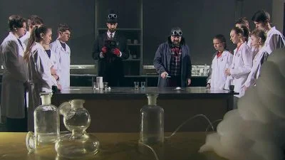 Skupina studentů v laboratoři s chemickým nádobím.