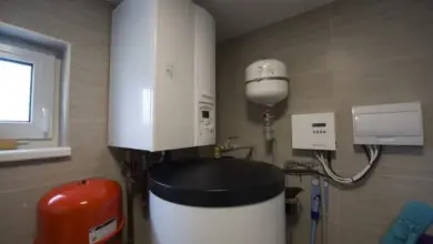 Bílý bojler s příslušenstvím pro ohřev vody v koupelně.